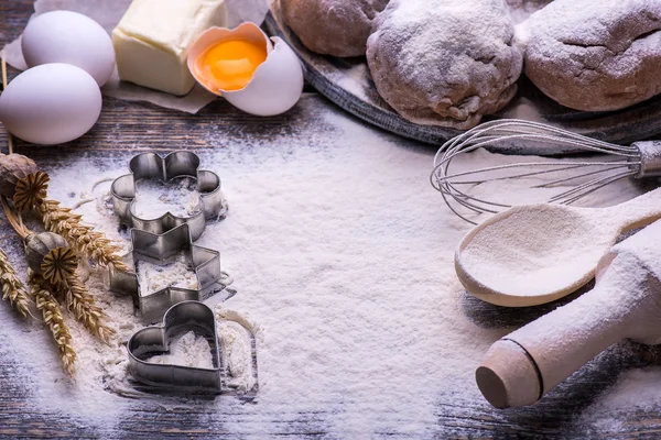 Galletas de Navidad. Ingredientes para hornear: masa, harina, formas para galletas sobre fondo de madera — Foto de Stock