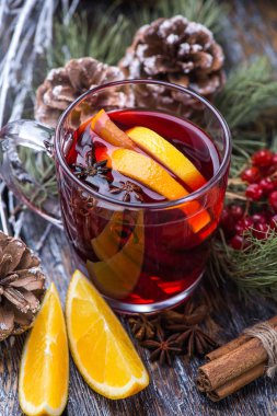 Sıcak bir içecek, sıcak kırmızı şarap cam ahşap arka plan üzerinde bir fincan