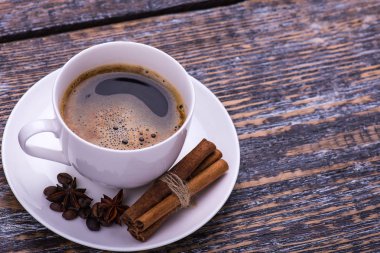 Kahve ve bisküvi, anason, tarçın, kahve çekirdekleri ahşap arka plan üzerinde