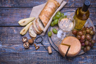 Beyaz şarap bir şişe, mantar şişe mürettebat ve ürünler - peynir, üzüm, fındık, zeytin, incir ahşap arka plan üzerinde bir dizi.