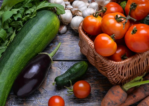 Récolte Légumes : tomates, concombres, courgettes, aubergine, oignon, ail, roquette sur le fond en bois — Photo