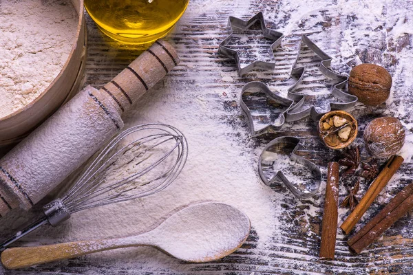 Galletas de Navidad. Ingredientes para hornear: masa, harina, formas para galletas sobre fondo de madera — Foto de Stock