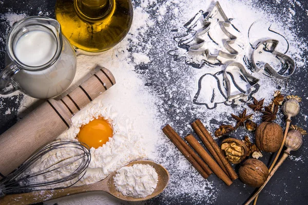 Galletas de Navidad. Ingredientes para hornear: masa, harina, formas para galletas sobre fondo de madera — Foto de Stock