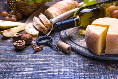 Beyaz şarap bir şişe, mantar, şişe vida ve ürünler - peynir, üzüm, fındık, zeytin, incir ahşap bir gemide bir dizi arka plan