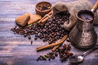 Kahve fincanı, kahve çekirdekleri ve bisküvi, ahşap arka plan üzerinde kalp şeklinde kurabiye