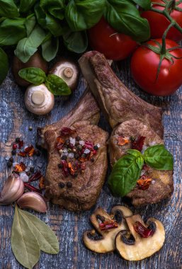 Ham sığır eti biftek, tuz, biber, sarımsak, biberiye ahşap gemide, arka plan.