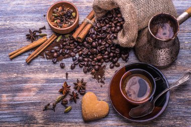 Kahve Kupası kahve çekirdekleri ve bisküvi, ahşap arka plan üzerinde kalp şeklinde kurabiye