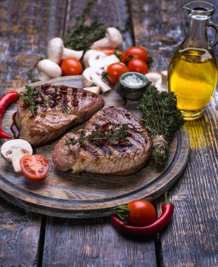  Dana biftek, tuz, biber, sarımsak, biberiye ahşap gemide, arka plan.
