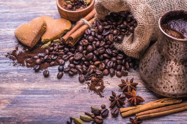 Kahve fincanı, kahve çekirdekleri ve bisküvi, ahşap arka plan üzerinde kalp şeklinde kurabiye