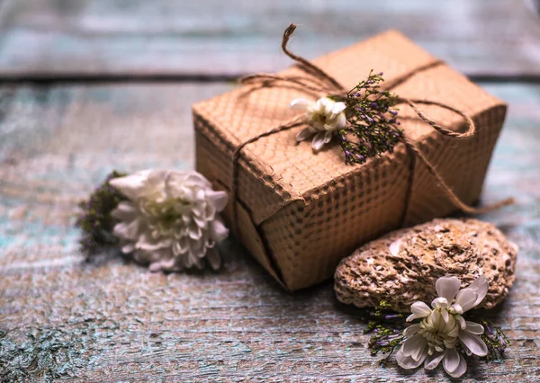 Caja de regalo y flores sobre fondo de madera — Foto de Stock