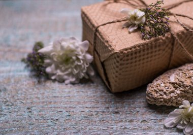 Mevcut kutusu ve ahşap arka plan üzerinde kırmızı çiçekler