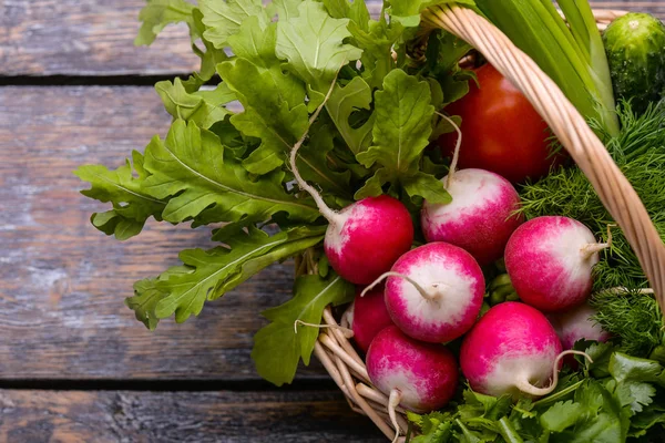 Овощи урожая: садисы, помидоры, огурцы, петрушка, лук, руккола в корзине на деревянном фоне — стоковое фото