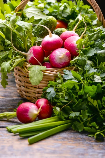 Recoltarea legumelor: sadishes, tomate, castraveți, patrunjel, ceapă, arugula la coș pe fundalul din lemn — Fotografie, imagine de stoc