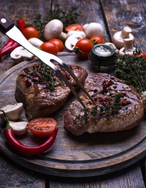 Dana biftek, tuz, biber, sarımsak, biberiye, mantar, domates, zeytin yağı, kekik kara tahta, arka plan üzerinde.