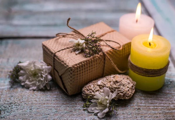 Ajuste de spa con flores en una mesa, velas, caja de regalo en el fondo de madera —  Fotos de Stock