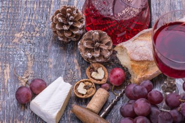 Kırmızı şarap sürahi, mantar şişe vida ve birtakım ürünler - peynir, üzüm, fındık, peynir, ekmek ahşap masa üzerinde arka plan