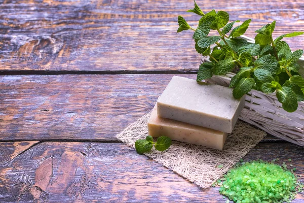 Spa setting  therapy with flowers, natural soap, natural sea salt,  mint isolated on a white wooden background.Seletive focus