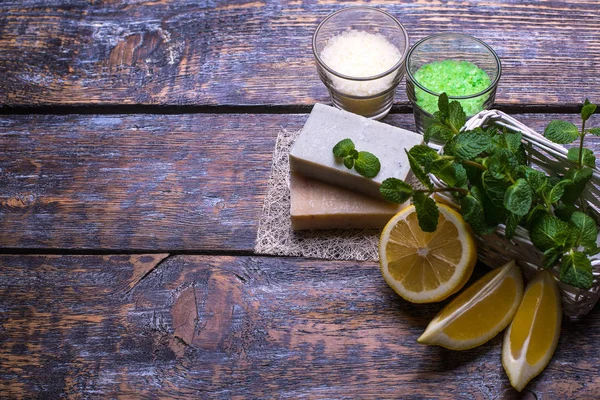 Spa setting  therapy with flowers, natural soap, natural sea salt, lemon slices, mint isolated on a white wooden background.Seletive focus