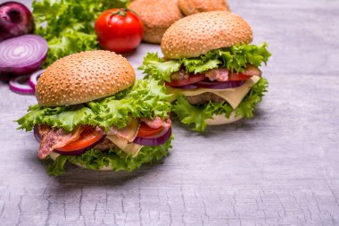 Zanaat sığır eti burger taze sebze, domates, peynir, omion, ahşap masa siyah arka plan üzerine izole üzerinde yeşil salata ile.