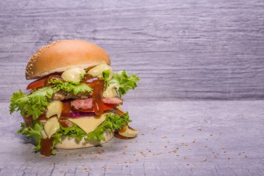 Zanaat sığır eti burger taze sebze, domates, peynir, omion, ahşap masa siyah arka plan üzerine izole üzerinde yeşil salata ile.