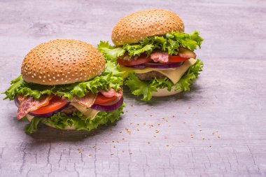 Zanaat sığır eti burger taze sebze, domates, peynir, omion, ahşap masa siyah arka plan üzerine izole üzerinde yeşil salata ile.