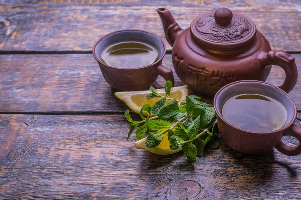 茶壶和柠檬 绿茶在木质背景下的切片 — 图库照片