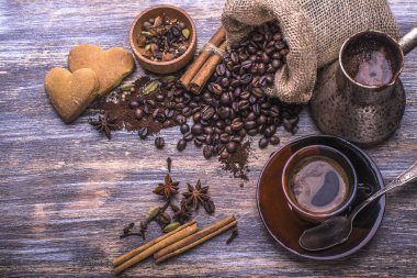 Kahve bir fincan, kahve çekirdekleri, baharatlar: tarçın, kakule, anason, Çerezler bir ahşap zemin üzerinde. Üstten Görünüm