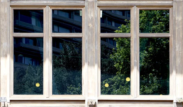 Wooden window architecture with green reflection in the glass — Stock Photo, Image