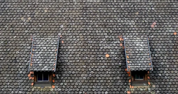 Brown old ceramic tile roof top shingles middle ages with two wi — Stock Photo, Image