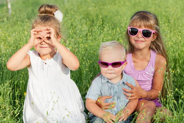 Happy brother and two sisters playing in park. — Stock Photo, Image