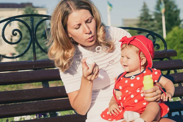 Glückliche Mutter und Tochter spielen im Park. — Stockfoto