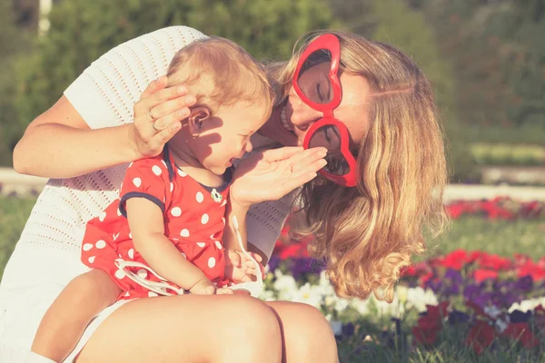 Glückliche Mutter und Tochter spielen im Park. — Stockfoto