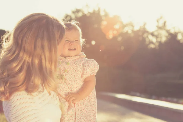 Glückliche Mutter und Tochter spielen im Park. — Stockfoto