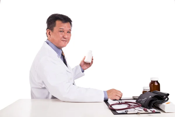 Maturé asiatique médecin tenant la médecine assis behin — Photo