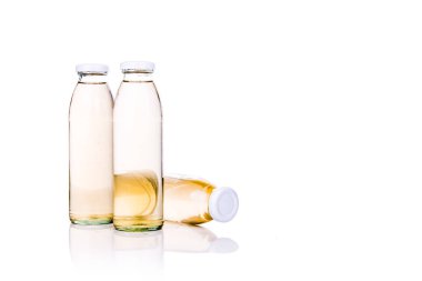 Beyaz arka plan üzerinde cam şişede şeffaf sıvı