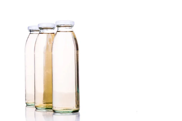 Liquido traslucido in bottiglia di vetro su fondo bianco — Foto Stock