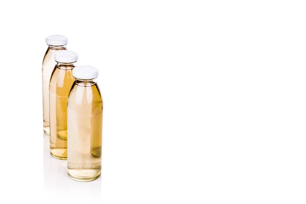 Tre liquidi traslucidi in bottiglia di vetro su fondo bianco — Foto Stock
