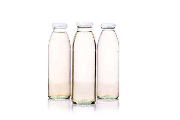 Liquido traslucido in bottiglia di vetro su fondo bianco — Foto Stock