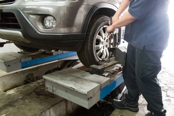 Mechanic fixing car aligner onto car wheel — Stock Photo, Image