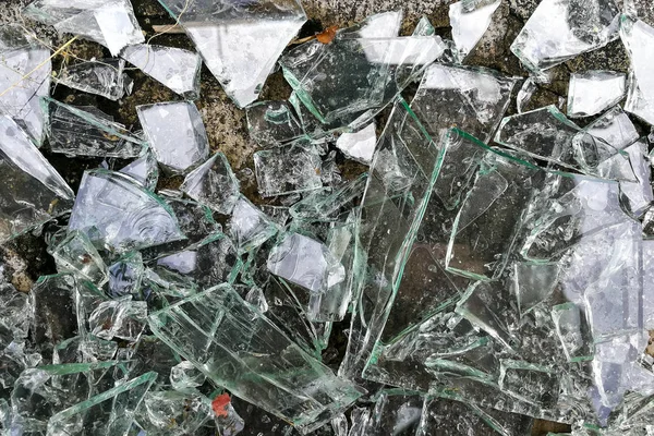 Heap of sharp shattered pieces broken glass on ground