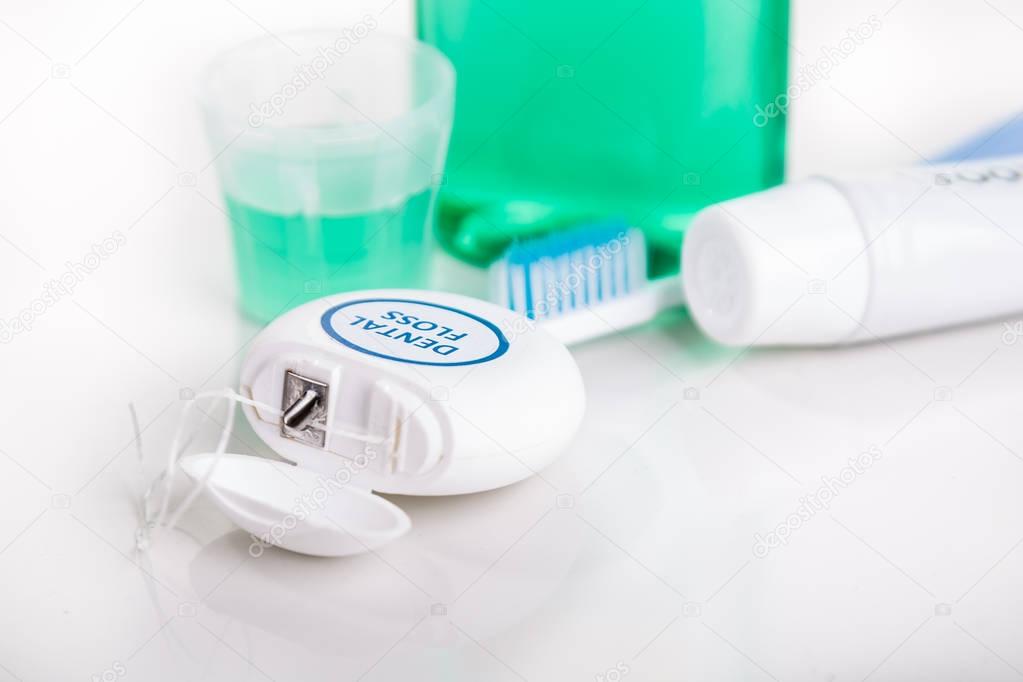 Dental floss focused with  toothbrush, toothpaste, mouthwash, at