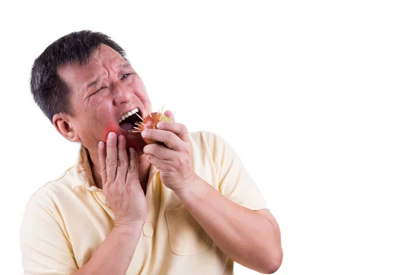 Концептуальный человек с зубной болью после укуса яблока с шипом — стоковое фото