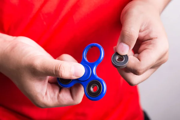 Persona que sostiene el peso desplazado de fidget spinner, peligroso f — Foto de Stock