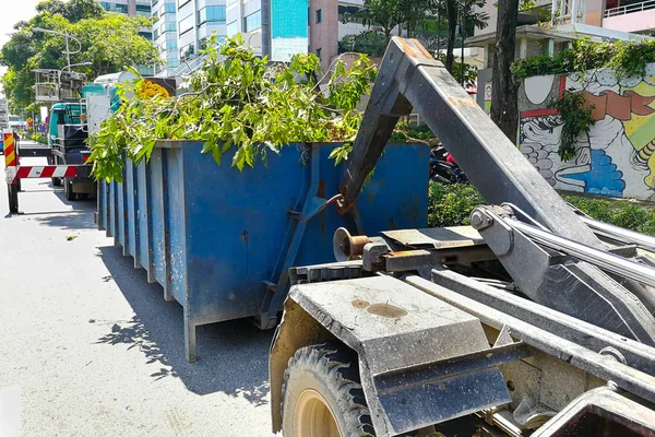 垃圾容器闩锁与园林垃圾树林里满载的卡车 — 图库照片