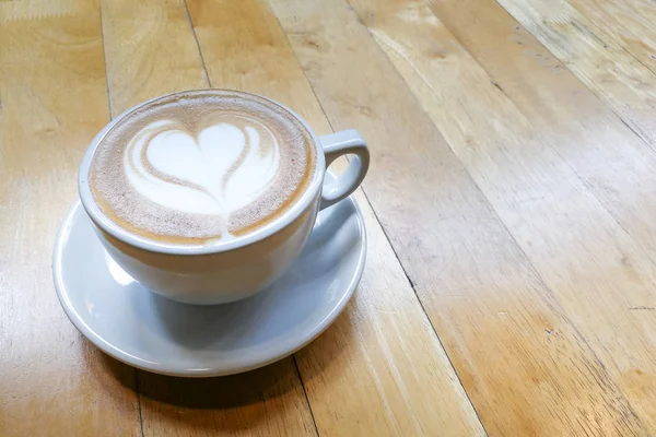 Cappuccino z pianki sztuki z miłości serca kształt na stole — Zdjęcie stockowe