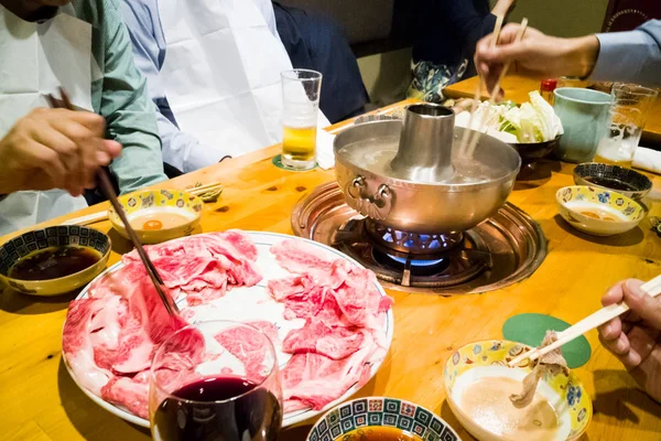 Menschen essen mit rohem japanischem Kobe-Rindfleisch shabu-shabu Dampfboot — Stockfoto