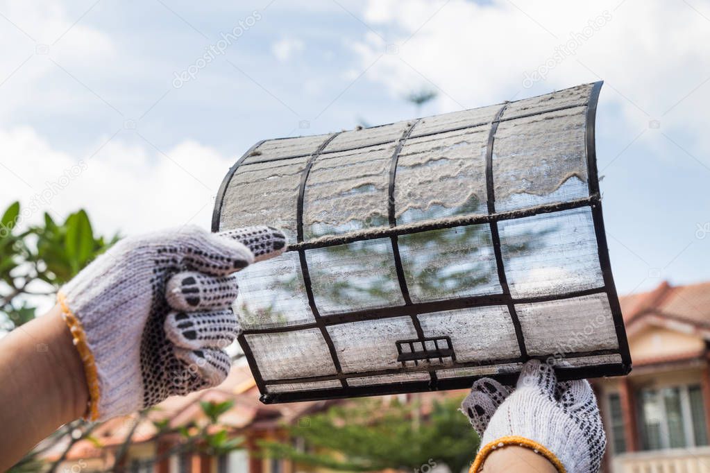 Person pointing on thick dirty dust on air conditioner filter