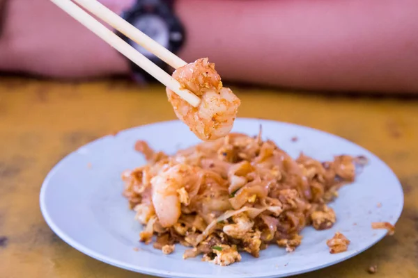 Sumpit memegang udang besar dari Penang Char Kuey Teow — Stok Foto