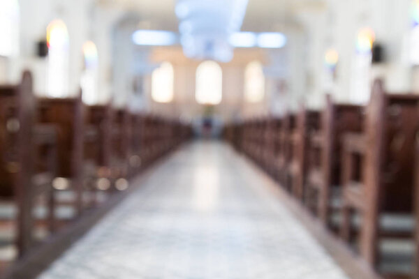 Defocused interior of Catholic church with pews