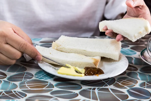Rad person gäller ångad bröd smör och kaya — Stockfoto